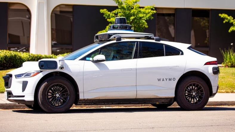 Waymo autonomous vehicle equipped with lidar and sensors parked on a city street