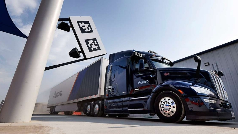 Semi-truck equipped with roof-mounted sensors outside logistics facility