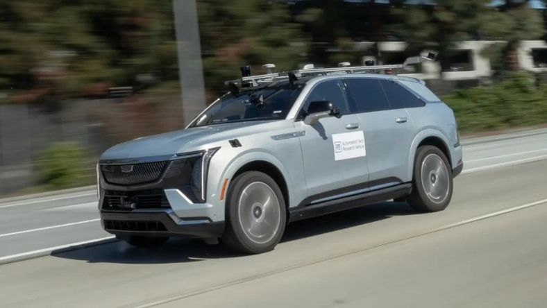 GM autonomous test vehicle driving on highway with roof-mounted sensors